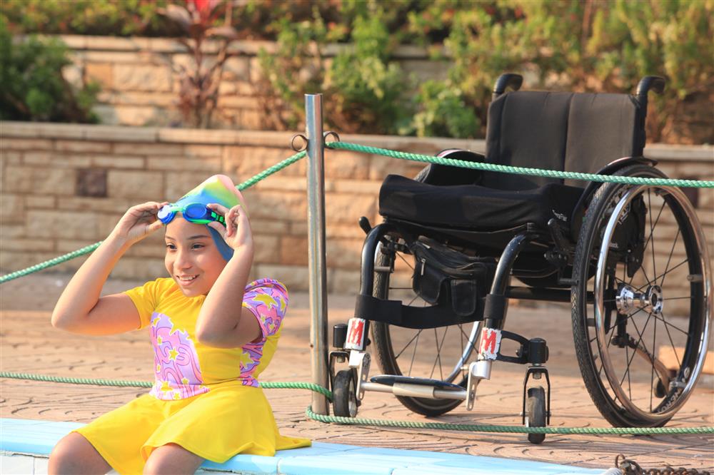 A child on a wheelchair going swimming.