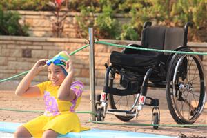 A child on a wheelchair going swimming.