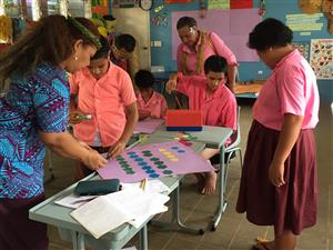 Project participants in uniforms  doing hands on activities in the the classroom.