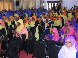 A room of pre primary teachers in colorful hijabs clap their hands and smile, after they have been trained on Inclusive Education.