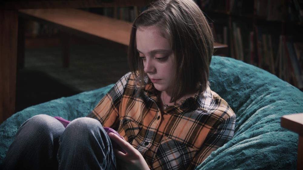 Girl sits in a bean bags, while reading on her tablet using Bookshare.