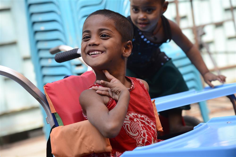 A picture of a smiling child with disabilities.