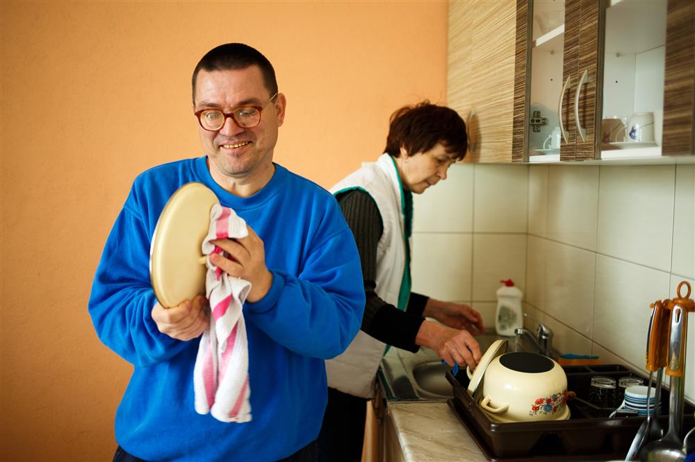 A person doing his dishes in the kitchen.