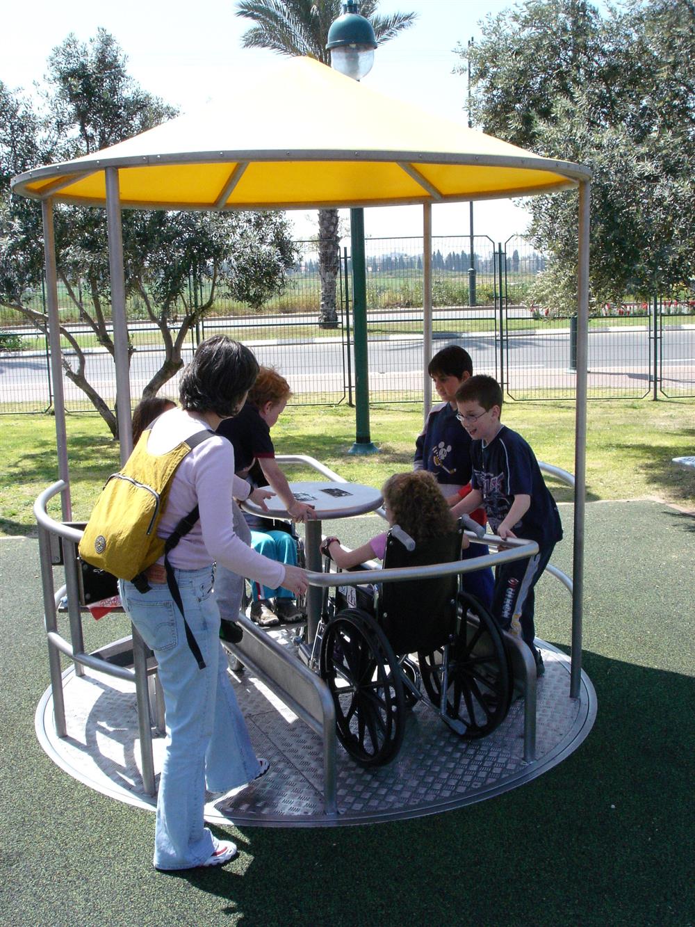 Children with and without disabilities playing on a playground with accessibility features.