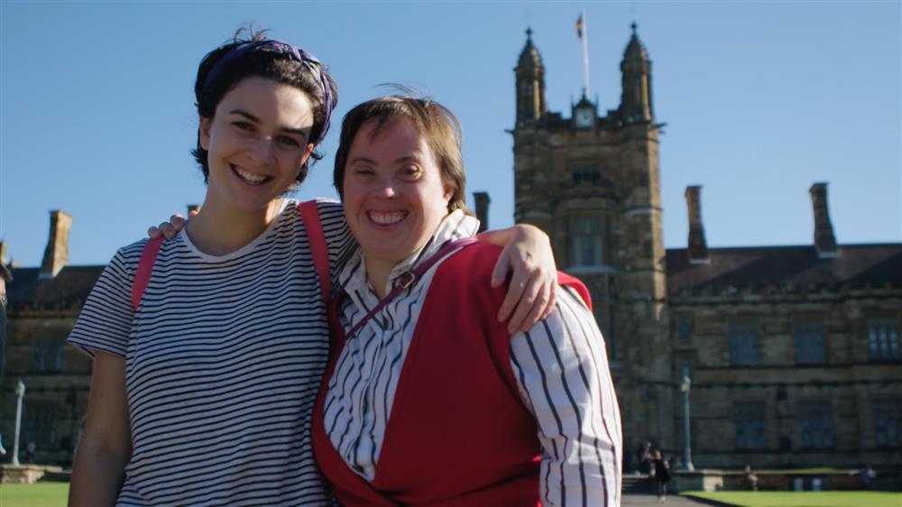 A project participant and her mentor hug in front of a British building.