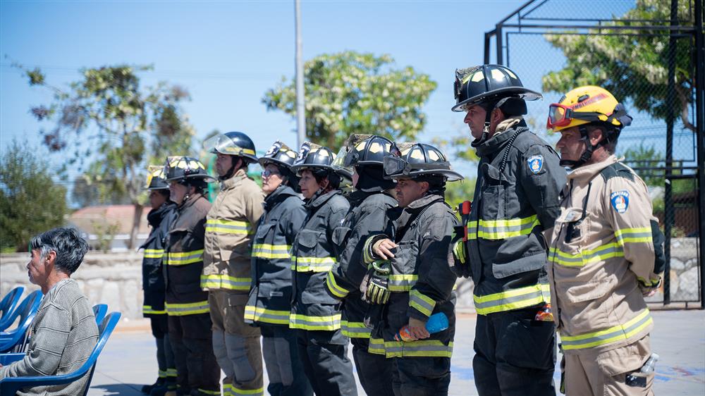 A diverse team of firefighters stands in uniform, ready and united. Their coordinated stance reflects dedication, equality, and teamwork—symbolizing collective responsibility in protecting others, regardless of gender or background.