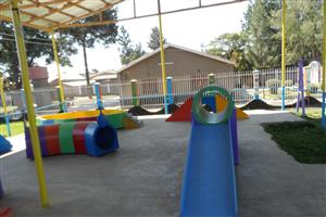 A colorful playground with slides, tunnels, and ramps stands ready for children’s play. The accessible design and sheltered space promote inclusion, ensuring that all children—regardless of ability—can safely learn, explore, and play together.
