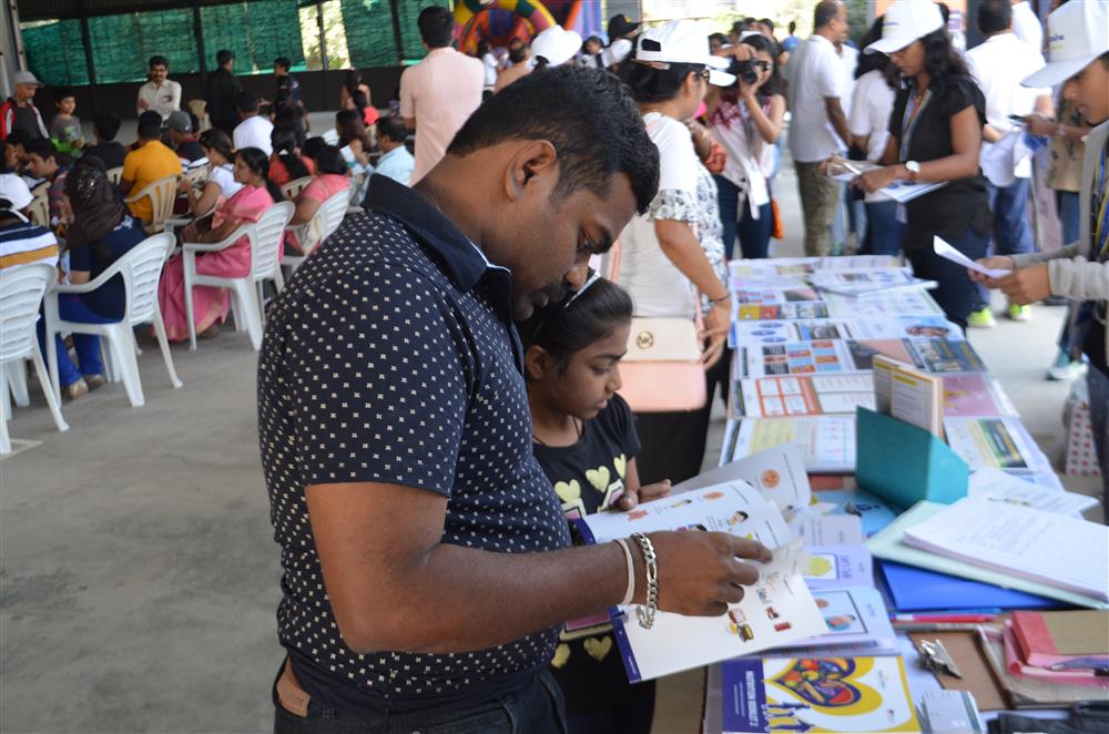 A father and his daughter are looking at information material at a information stall.