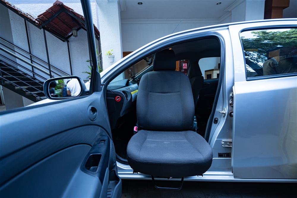 A side view of a car. The passenger seat is turned 90 degrees and reaching out of the car, suggesting an accessbile way of entering the vehicle.