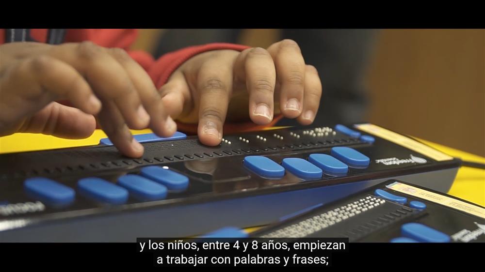 Fingers of a child are touching a Braitico keyboard.