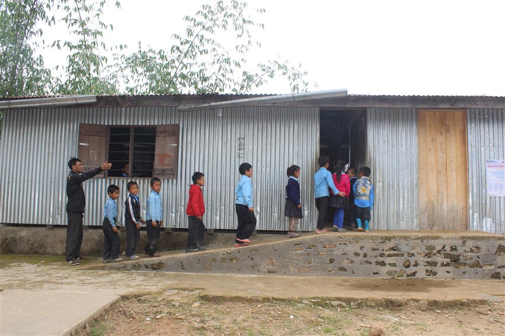 Children walking on a ramp to enter a school facility.