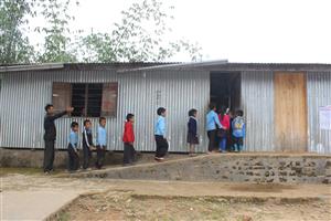 Children walking on a ramp to enter a school facility.