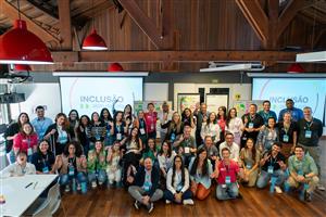 A diverse group of people smiling together during a workshop titled “Inclusão além da cota” (Inclusion beyond the quota). The participants are of different genders, backgrounds, and abilities, embodying unity and equality in an inclusive learning environment.
