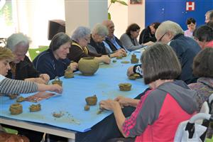 Elderly people at a pottery workshop.