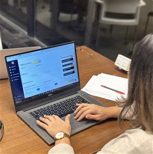 A woman with one hand on the keyboard of her laptop and the other on the trackpad. The screen of the laptop displays Jobsability portal showing the chat support, profile completion and other features.