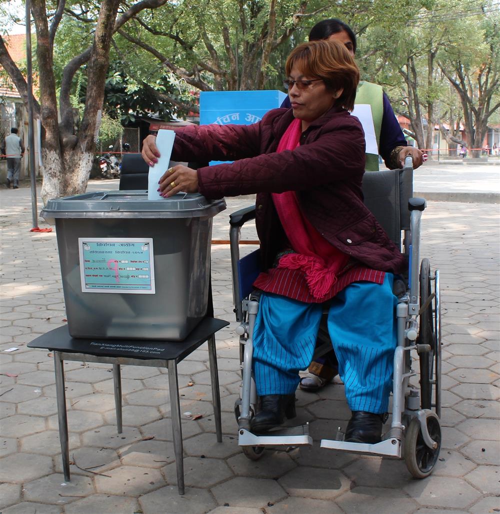 “A women with a physical disability casts her mock ballot in an accessible environment.” © Suraj SIGDEL, International Foundation for Electoral Systems