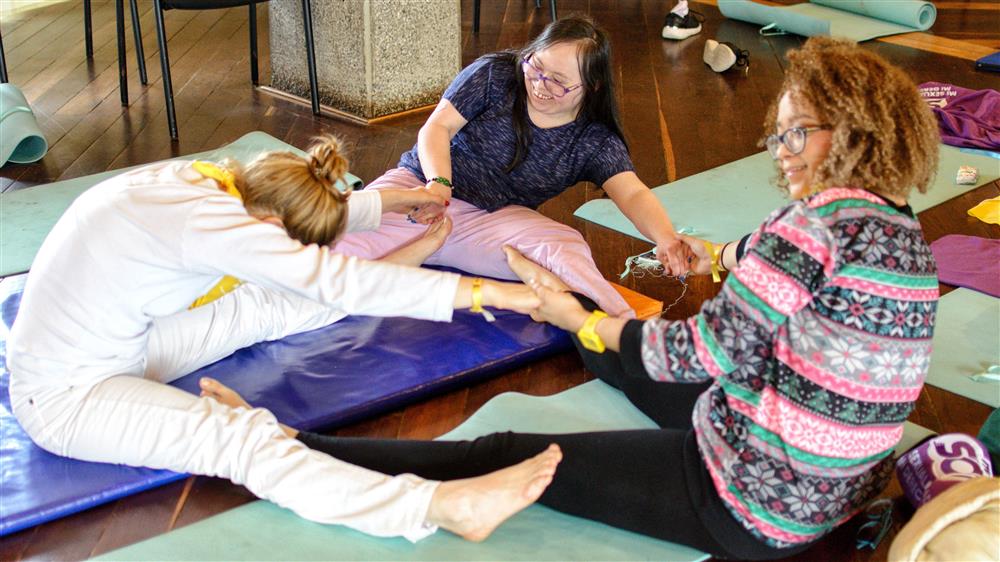 Three persons doing stretching exercises together.