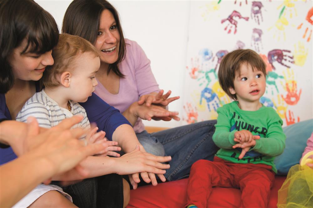 Children learning a song with their parents.